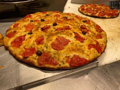 ...fatto con farina di semola, lievito, acqua e olio al quale si aggiungono pomodori, origano e olive